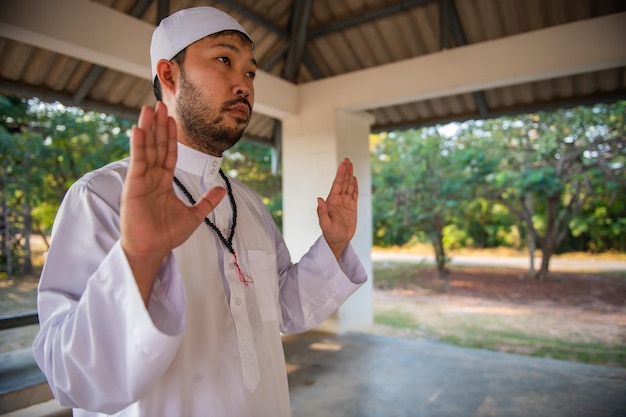 Oración del hombre islam asiático Joven musulmán rezando Concepto del festival de Ramadán