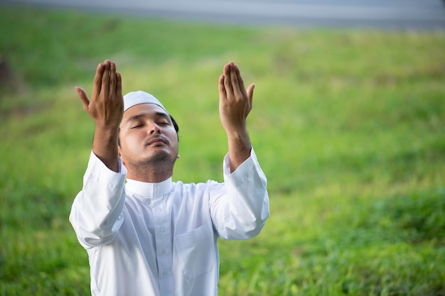 Oración del hombre islámico asiático, oración musulmana joven, concepto del festival Ramadán