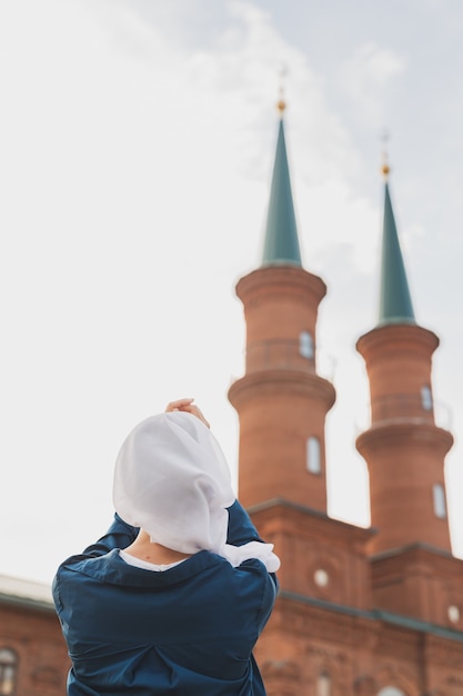 La oración de la mujer musulmana usa el hijab en ayunas reza a allah en el fondo de la mezquita