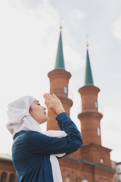 La oración de la mujer musulmana usa el hijab en ayunas reza a allah en la mezquita