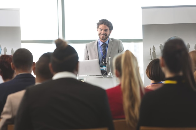 Orador masculino con una computadora portátil habla en un seminario de negocios