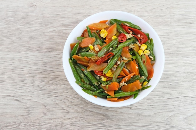 Orak arik sayur o verduras salteadas con zanahoria, frijol, maíz y huevo Servido en tazón blanco