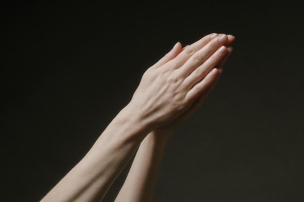 Foto orando manos a dios en la oscuridad. manos de mujer llegando a dios o pidiendo ayuda al estilo barokko