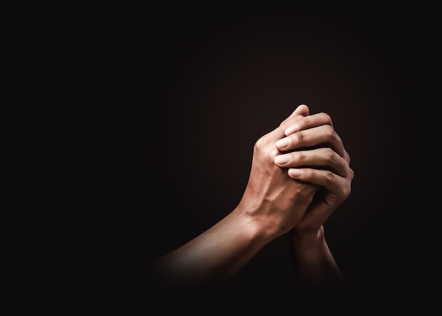 Foto orando manos con fe en la religión y creencia en dios en la oscuridad. poder de esperanza o amor y devoción.