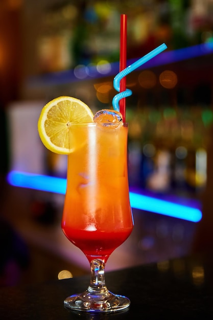 Orange alkoholische Cocktails, dekoriert mit einer Zitronenscheibe auf der Theke eines Nachtclubs