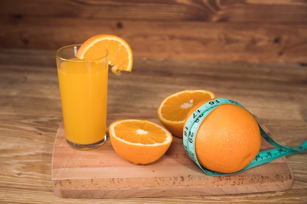 Orange auf dem Tisch, Maßband und Orangensaft