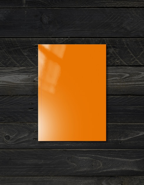 Orange Booklet Cover lokalisiert auf schwarzem Holzhintergrund, Modellschablone