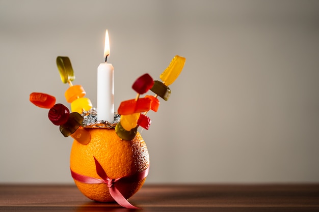 Orange Christingle é um objeto simbólico usado nos serviços do Advento, Natal e Epifania de muitas denominações cristãs