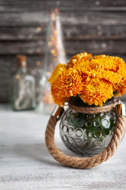 Orange Chrysanthemenblumen auf rustikalem Tisch.