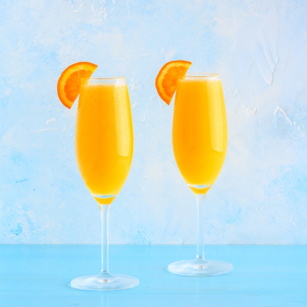 Orange Cocktails in Gläsern auf einem Holztisch