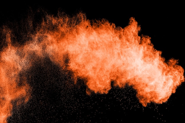 Orange Farbpulverexplosion auf schwarzem Hintergrund.