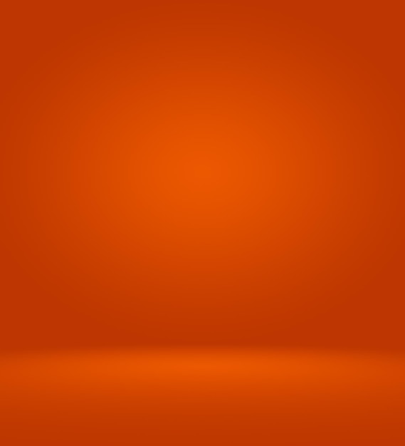 Foto orange fotostudio hintergrund vertikal mit weicher vignette. hintergrund mit weichem farbverlauf. studiokulisse auf bemalter leinwand.