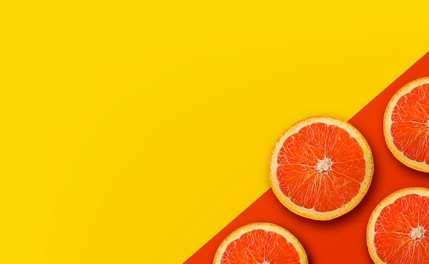 Orange Frucht auf gelbem und rotem Papierhintergrund