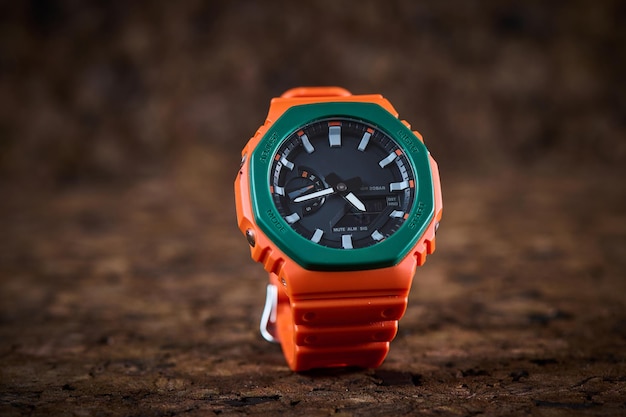 Orange helle Armbanduhr auf hölzernem Hintergrund