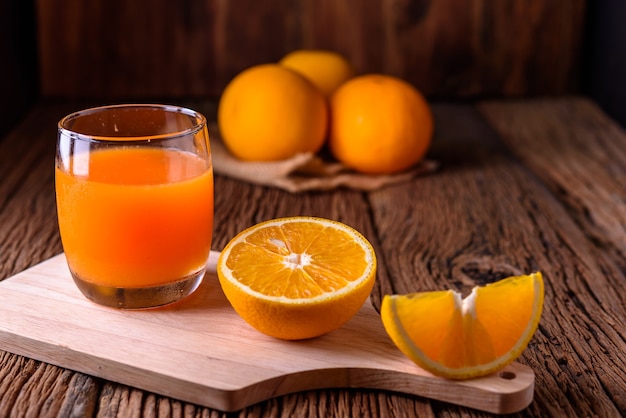 Orange Juce und Orange auf altem Holztisch