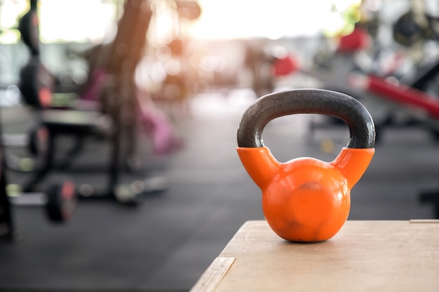 Orange Kettlebell zog eine hölzerne Kiste an.