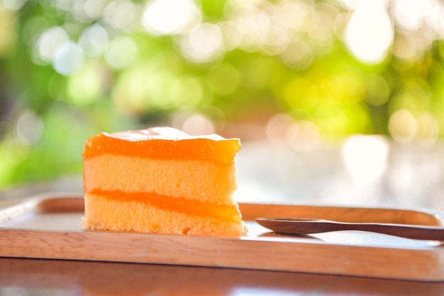 Orange Kuchen auf hölzerner Platte