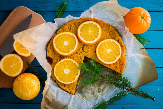 Orange Kuchen im Backpapier verziert mit Tannenzweig