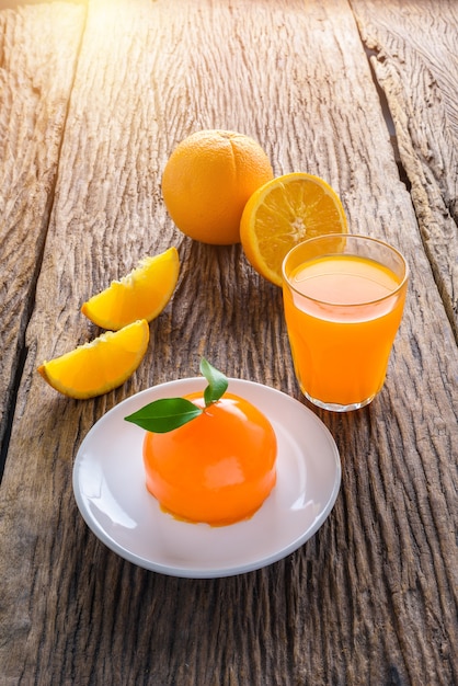 Orange Kuchen und Glas frischer Orangensaft und voll, halbe orange Frucht auf Holztisch