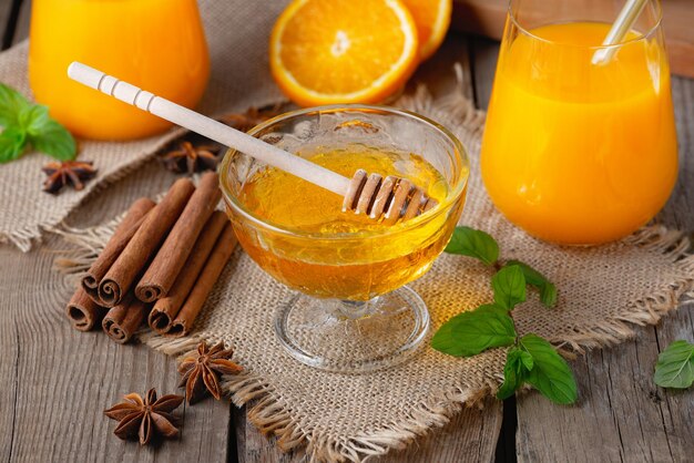 Orange Kürbis gewürzter Herbstcocktail mit Zimt und Honig auf einem alten Holztisch