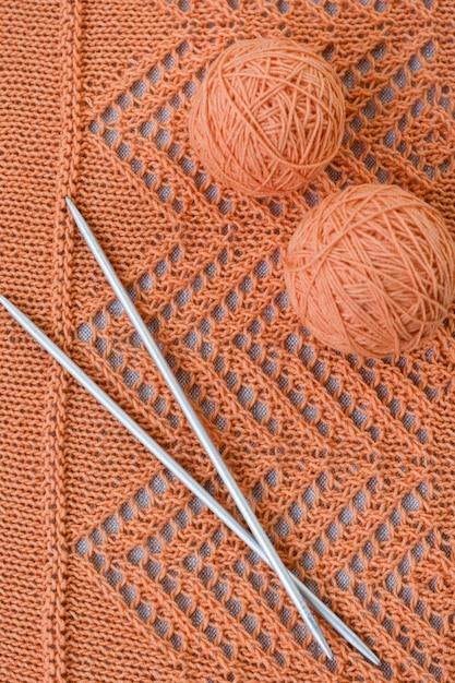 Orange Kugeln Strickmuster und Stricknadeln