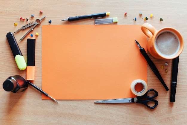 Orange leeres Blatt mit vielen Briefpapiergegenständen