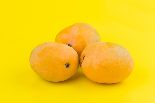 Orange Mango auf gelbem Grund