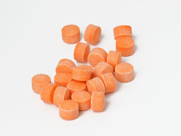 Orange Pillen auf weißer Oberfläche, Vitamin C, Nahaufnahme