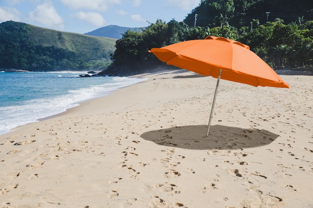 Orange Regenschirm auf der Strandcollage