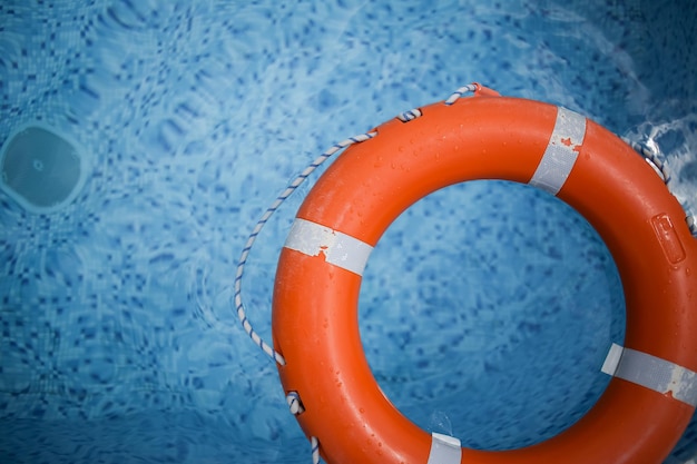 Orange Rettungsring im Pool Orange Rettungsring auf dem Hintergrund des Wassers Sommerurlaub-Konzept