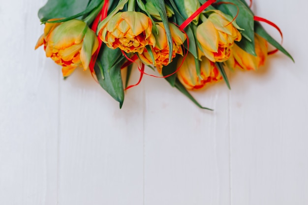 Orange Tulpen auf weißem hölzernem Hintergrund