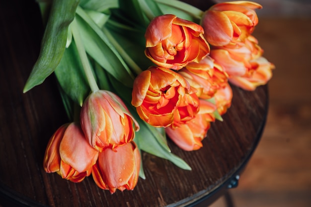 Orange Tulpen über hölzernen Tischhintergrund