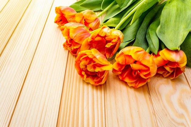 Orange Tulpenblumen auf einem Holztisch