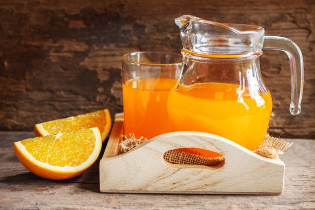 Orange und Orangensaft auf hölzernem Hintergrund