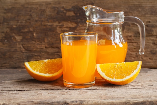Orange und Orangensaft auf hölzernem Hintergrund