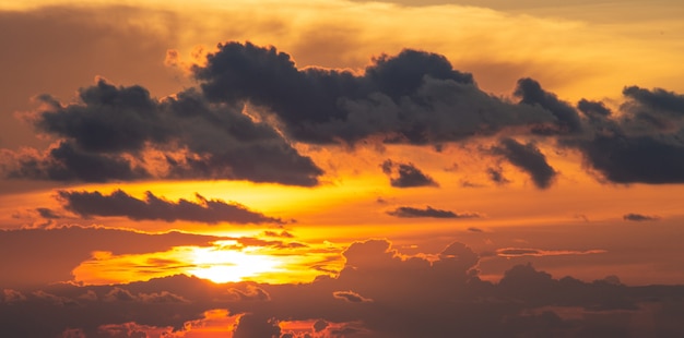 Orange und roter Sonnenuntergang- oder Sonnenaufganghimmel der Dramatik mit Wolke