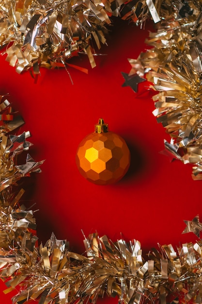 Orange Weihnachtskugel Spielzeug auf rotem Hintergrund