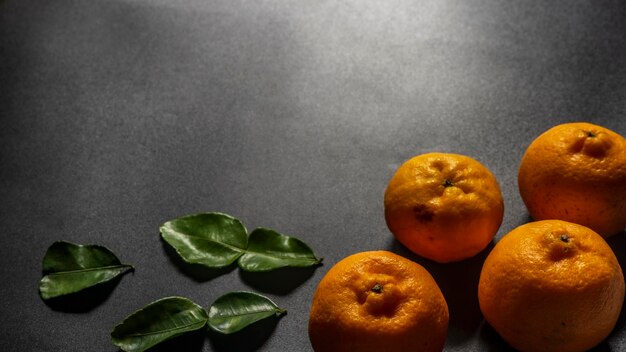 Orangefarbene Früchte mit Blättern als Hintergrund
