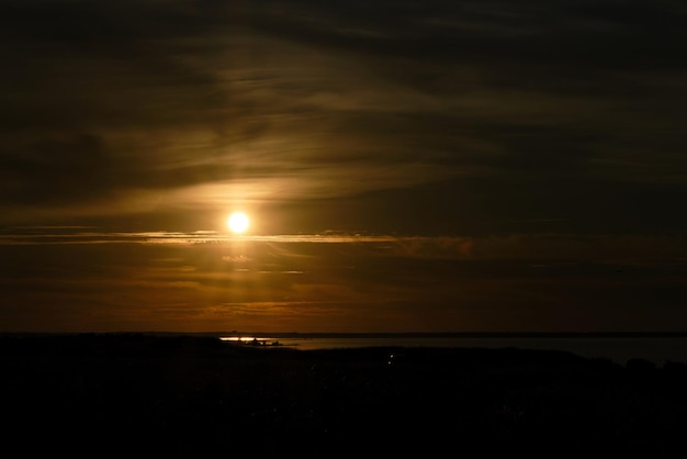 Orangefarbene Sonnenstrahlen über Feld und Teich Region Ilmensee Nowgorod Russland