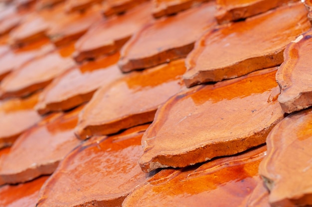 Orangefarbene Tonziegel, die sich auf dem Dach überlappen Geometrisches Muster aus alten Fliesen Selektiver Fokus Shallow DOF Horizontal