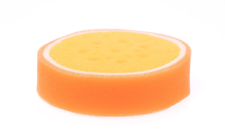 Foto orangefarbener schwamm isoliert auf weißem hintergrund.