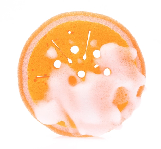 Orangefarbener Schwamm nass mit Schaum isoliert auf weißem Hintergrund.
