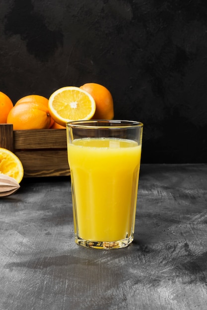 Orangen und frischer Orangensaft auf einem schwarzen Hintergrund