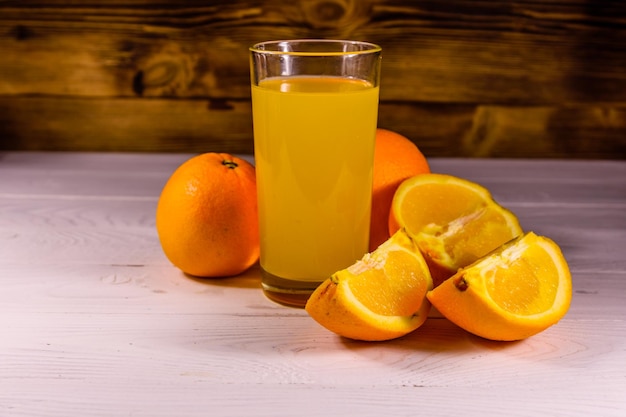 Orangen und Gläser mit Orangensaft auf einem Holztisch