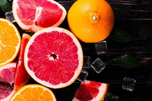 Orangen- und Grapefruitsaft auf einem hölzernen schwarzen Hintergrund