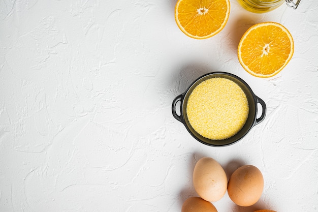 Orangen- und Mandarinenkuchen mit Polenta-Zutaten, mit Eiern und Honig, auf weißem Steintischhintergrund, Draufsicht flach, mit Kopierraum für Text