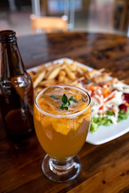 Orangencocktail, begleitet von einem Teller mit Essen