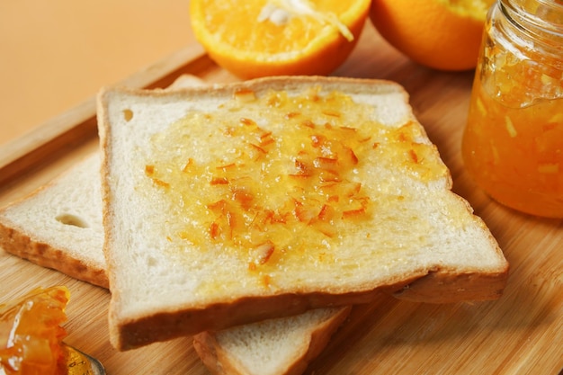 Orangenfruchtaufstrich auf einem Brot auf dem Tisch