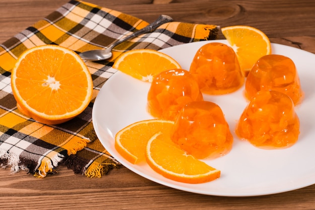 Orangengelee und orange Scheiben auf einer weißen Platte