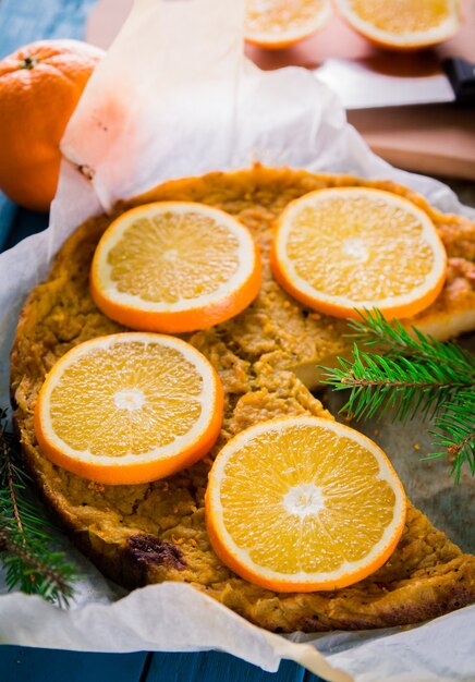 Orangenkuchen in Backpapier mit Tannenzweig dekoriert